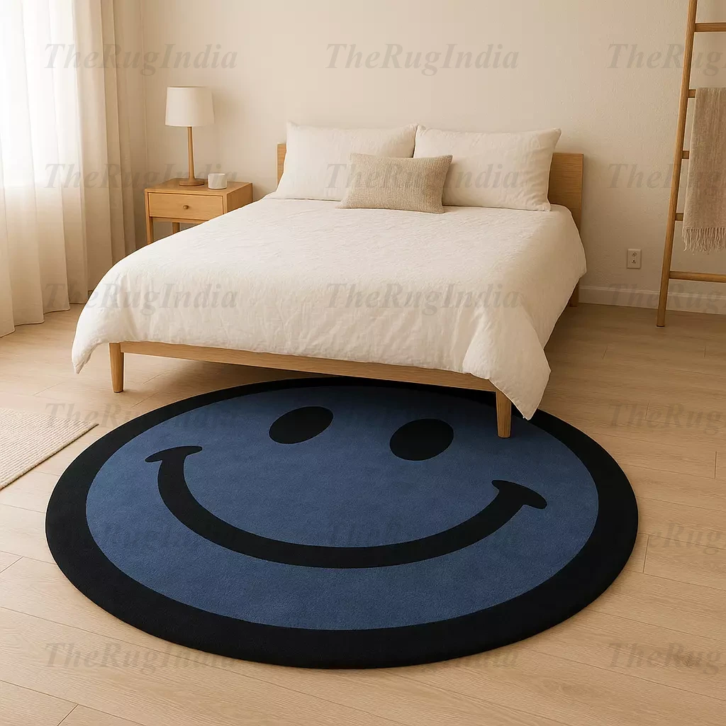 Hand-tufted round blue rug with black smiley face, placed in a modern living room with light wood flooring and minimalist chairs.