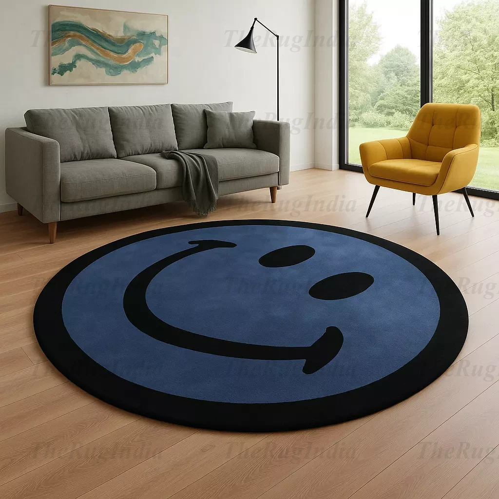 Hand-tufted round blue rug with black smiley face, placed in a modern living room with light wood flooring and minimalist chairs.