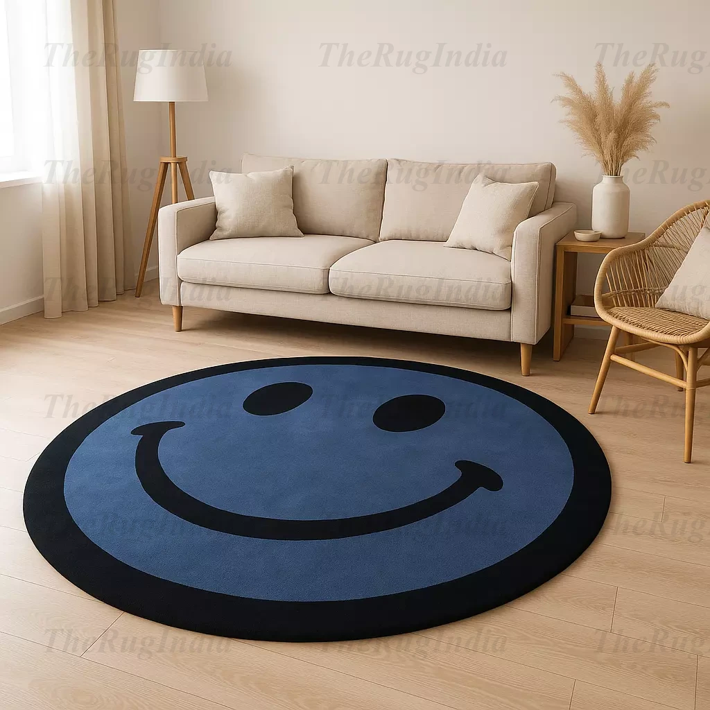Hand-tufted round blue rug with black smiley face, placed in a modern living room with light wood flooring and minimalist chairs.